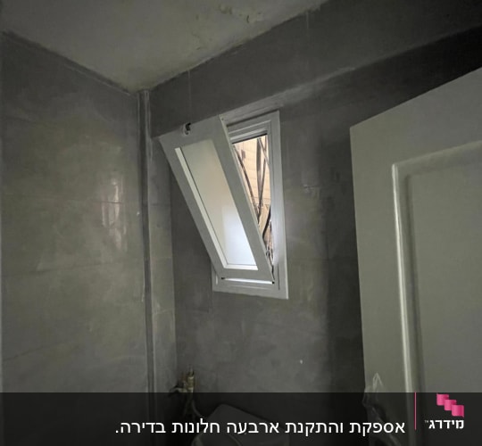 חלון אלומיניום פתוח בחדר אמבטיה אפור